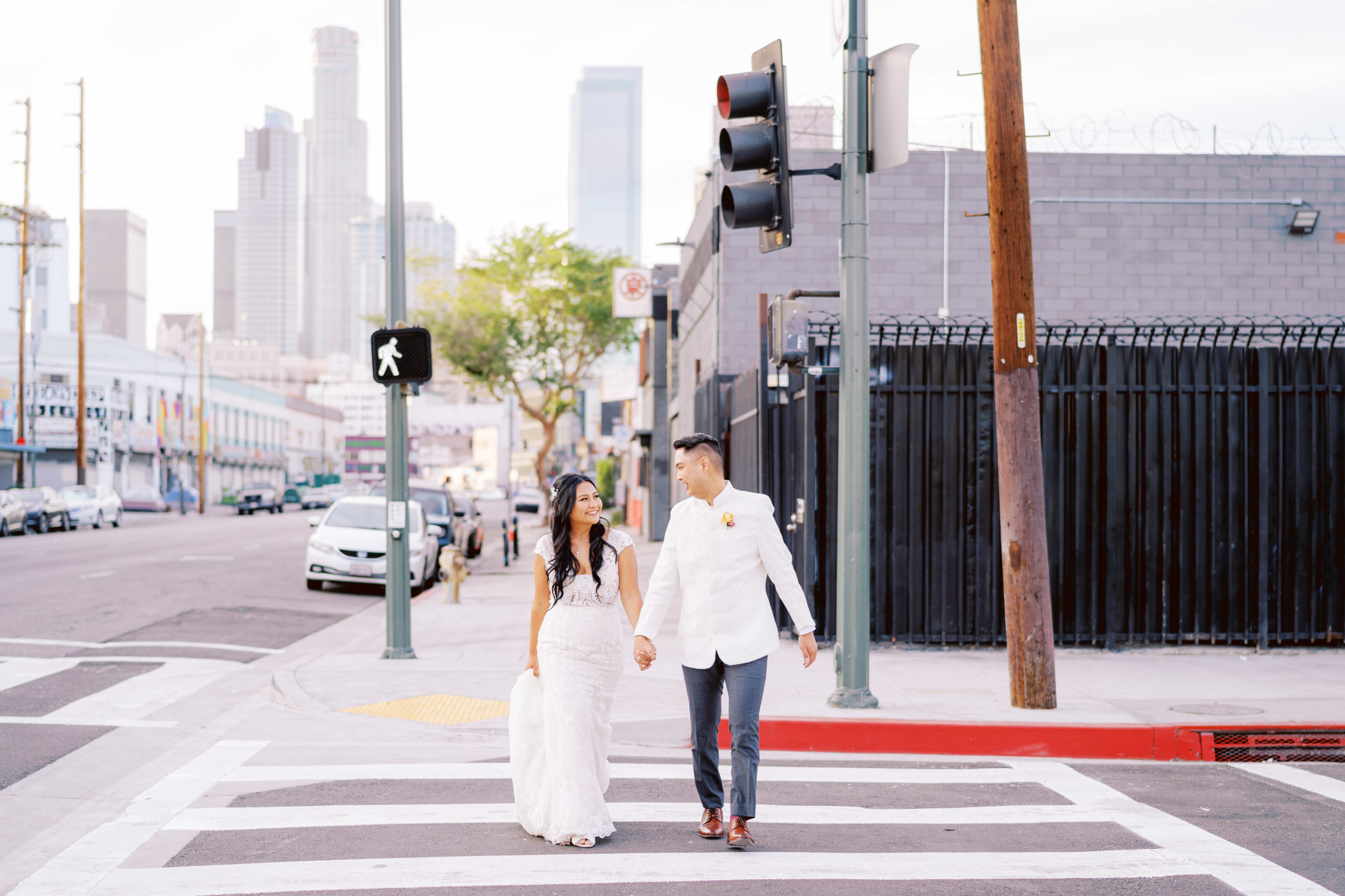 bride and groom walk hand in hand down the street in DTLA