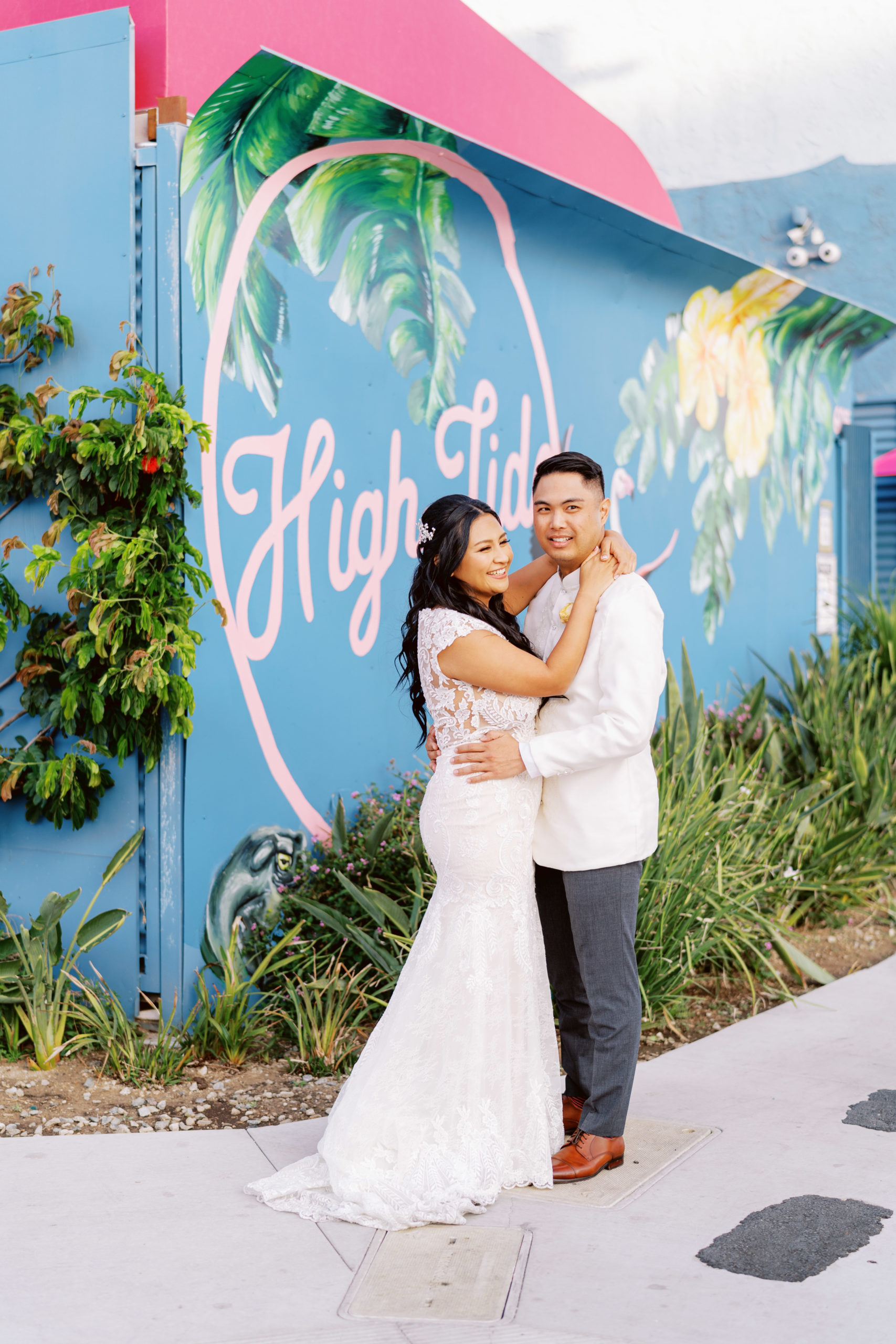 bride and groom pose in front of buildings in DTLA