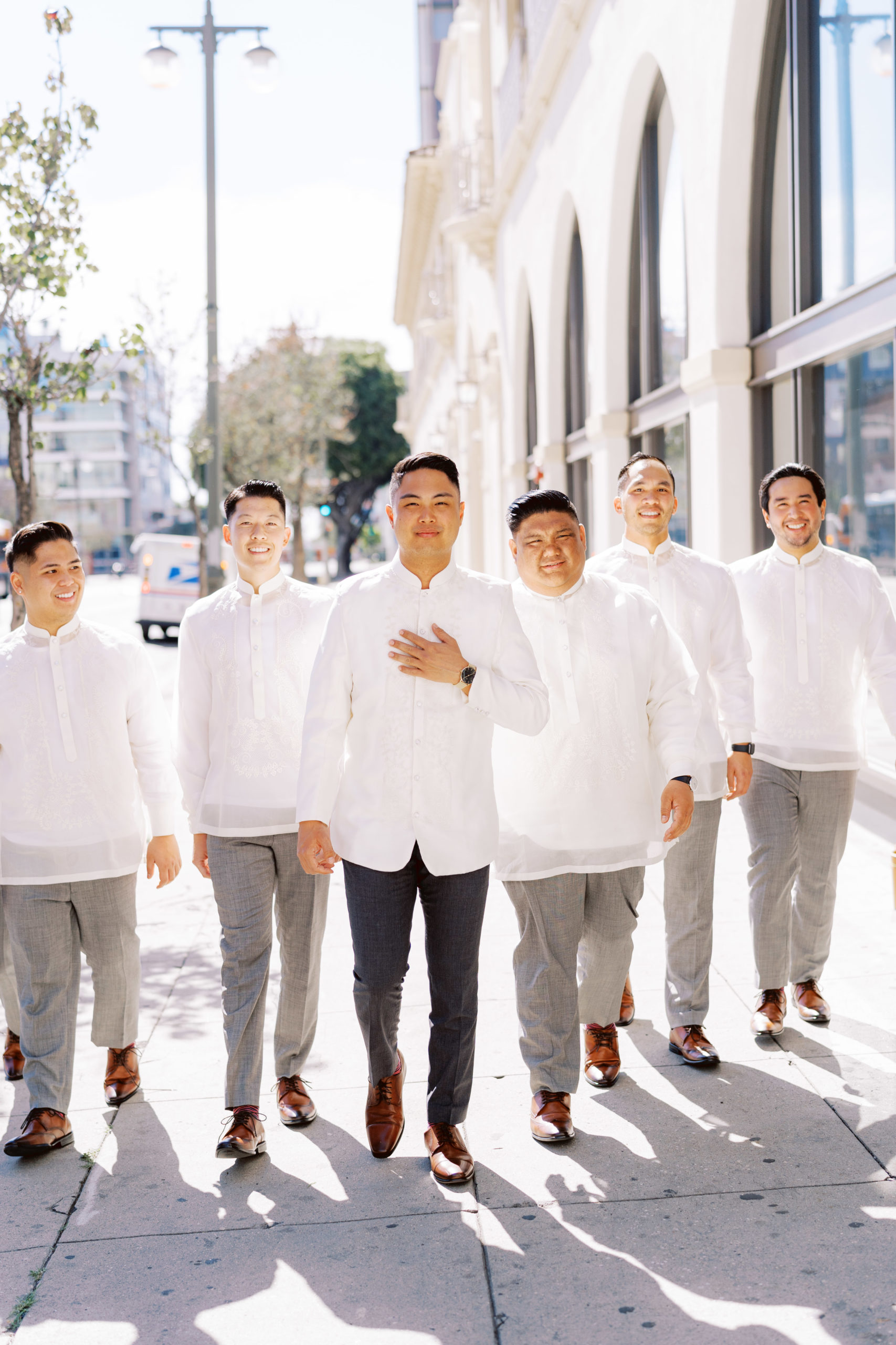 Groom with groomsmen in white traditional suits
