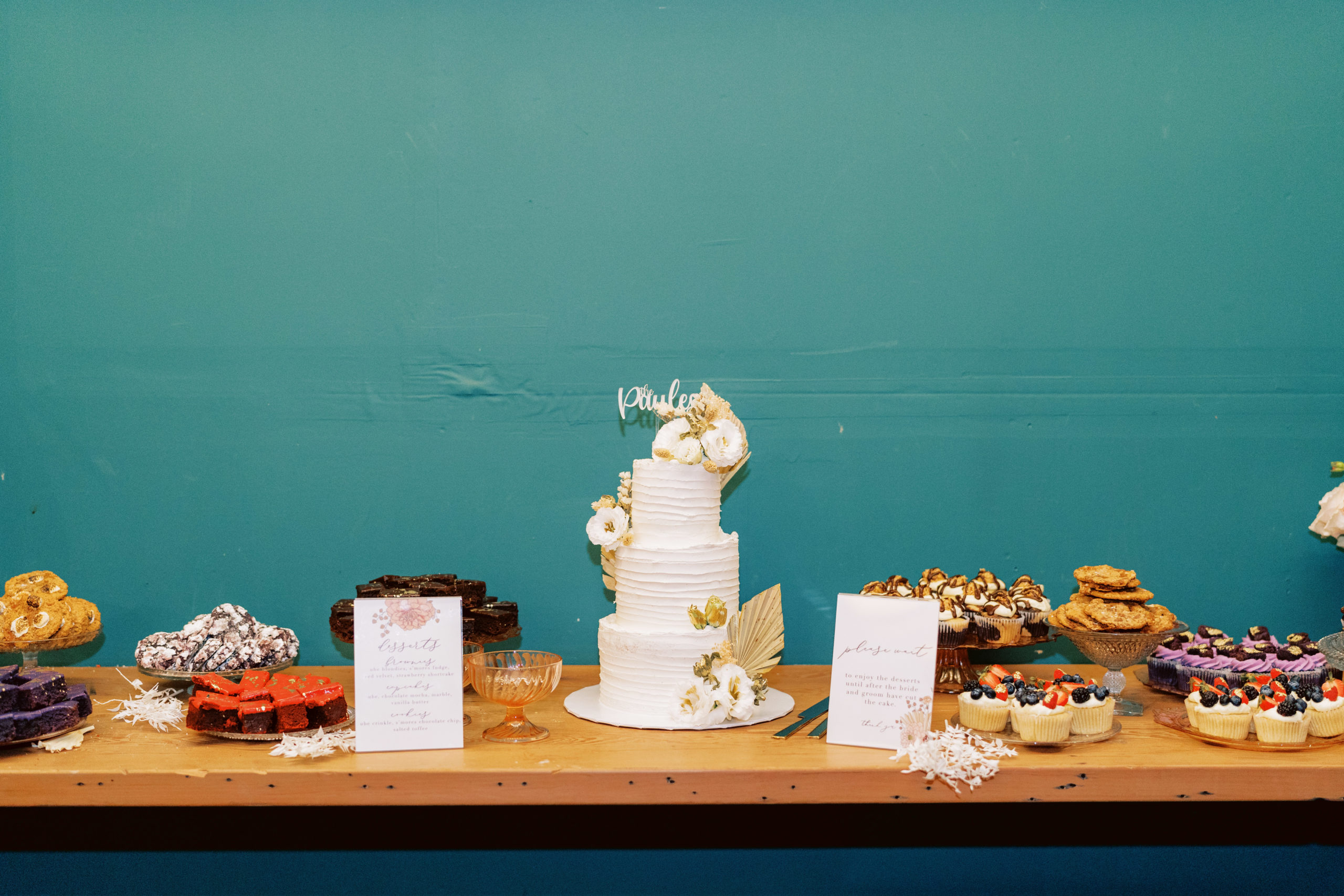 dessert table with three tier white wedding cake