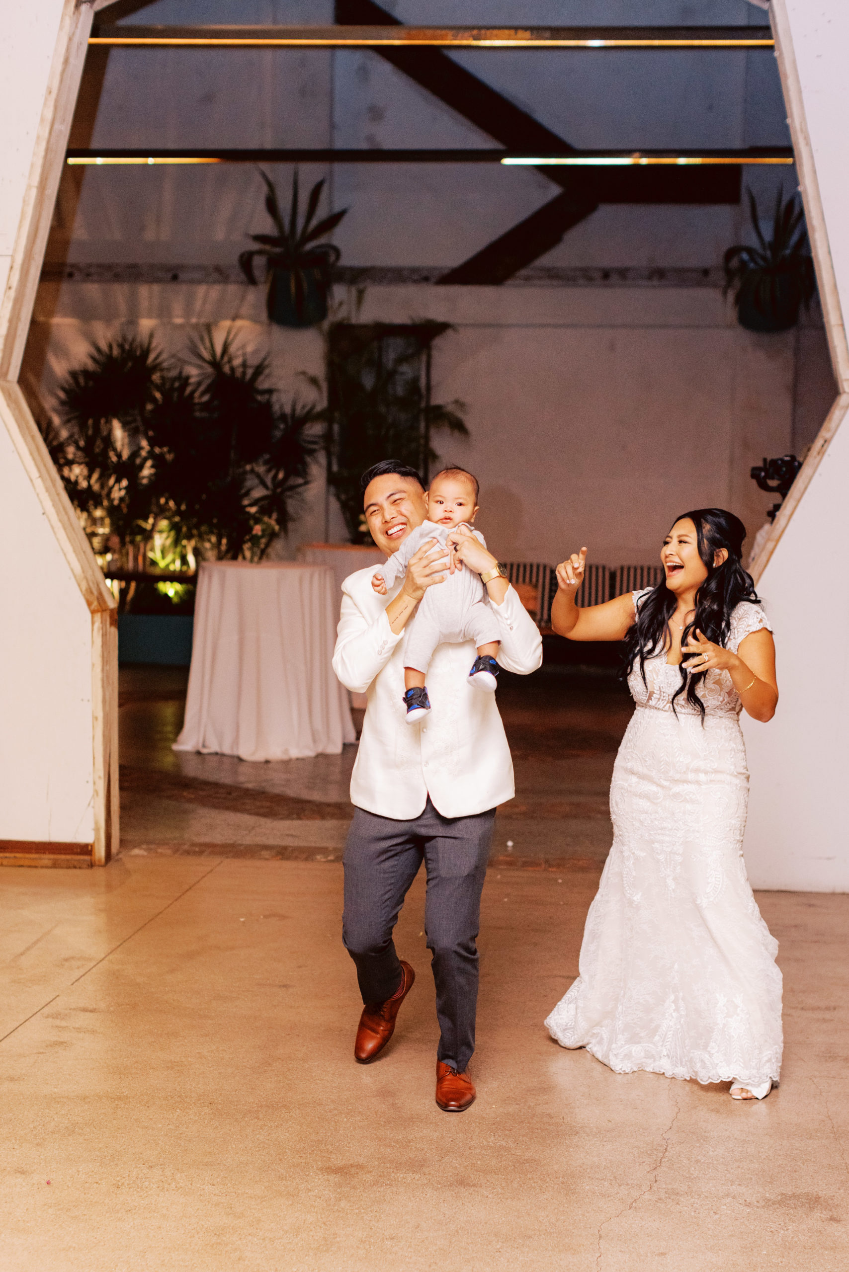bride and groom walk into wedding reception at The Valentine DTLA with their baby
