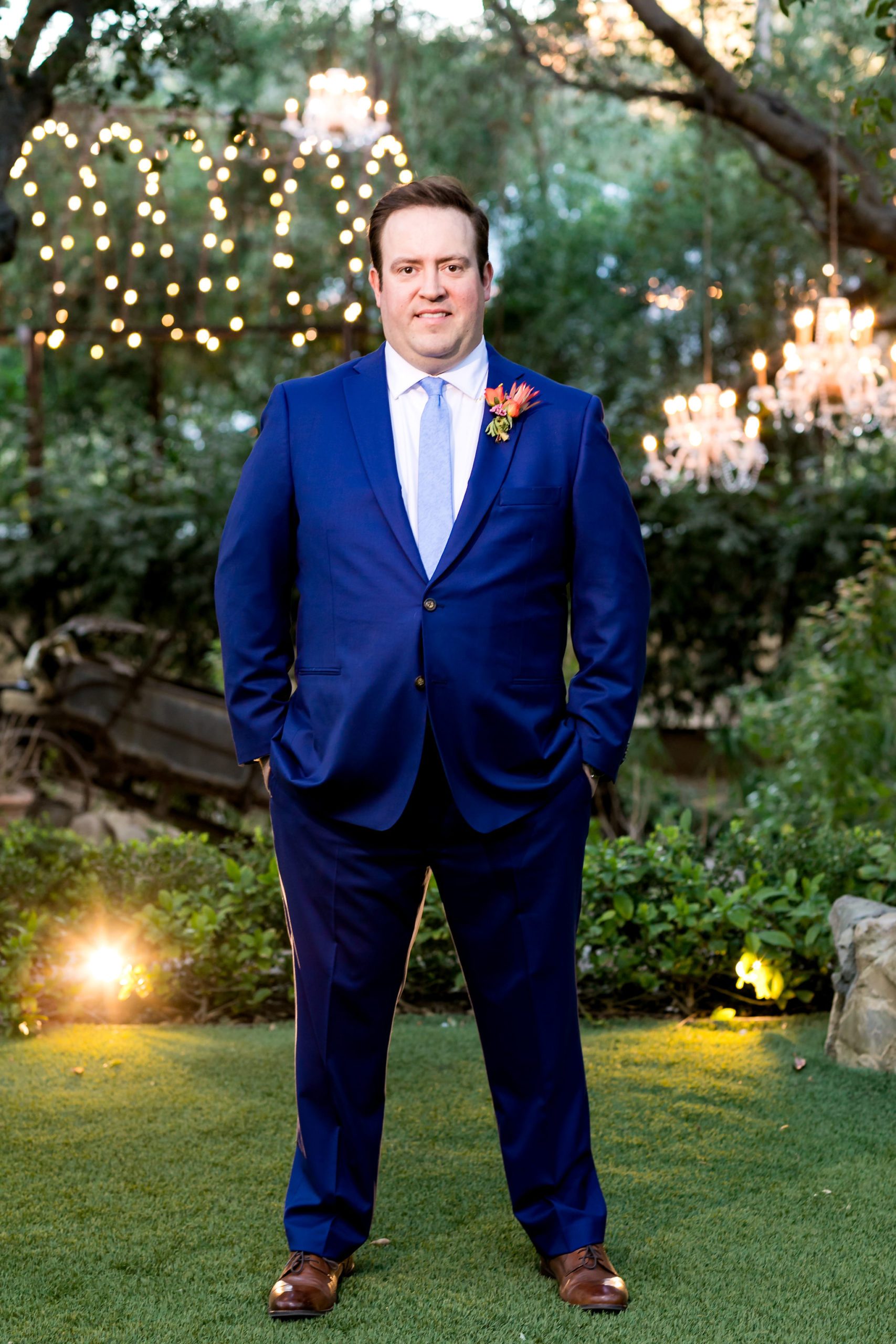 groom in bright blue suit and tie and orange boutonniere