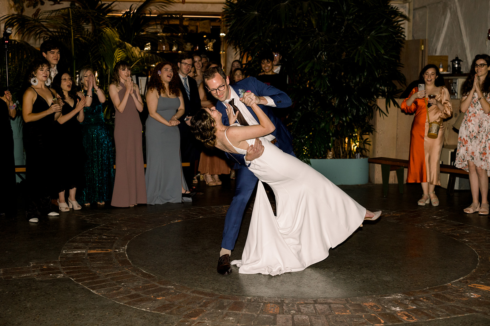 bride and groom dancing with guests during wedding reception 