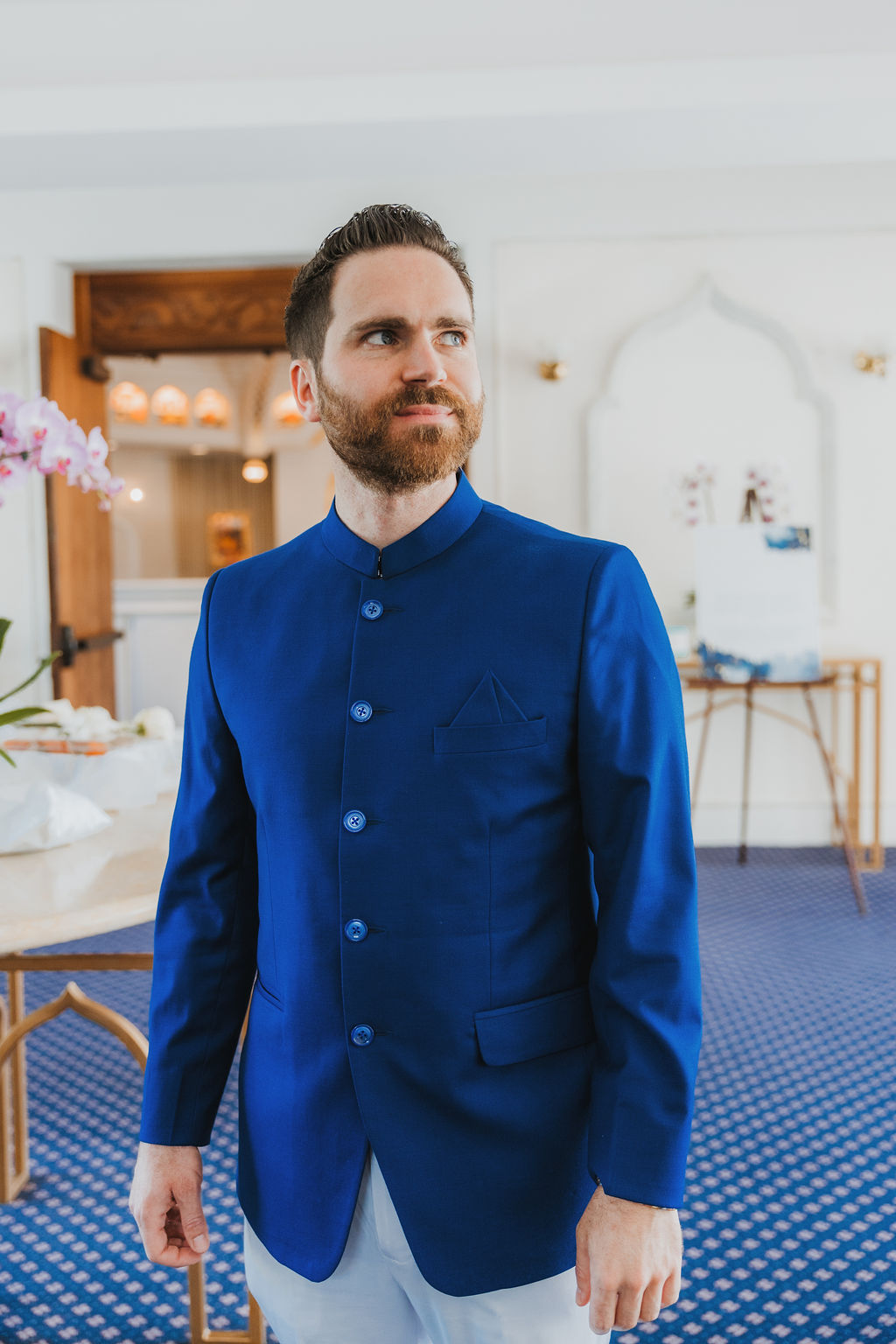 groom with beard wearing cobalt blue suit getting ready for his multi cultural wedding at Lake Shrine in Los Angeles