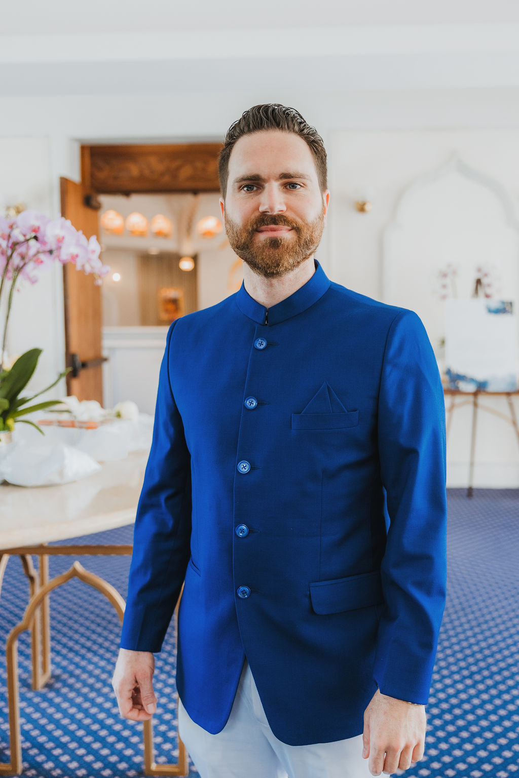groom with beard wearing cobalt blue suit getting ready for his multi cultural wedding at Lake Shrine in Los Angeles