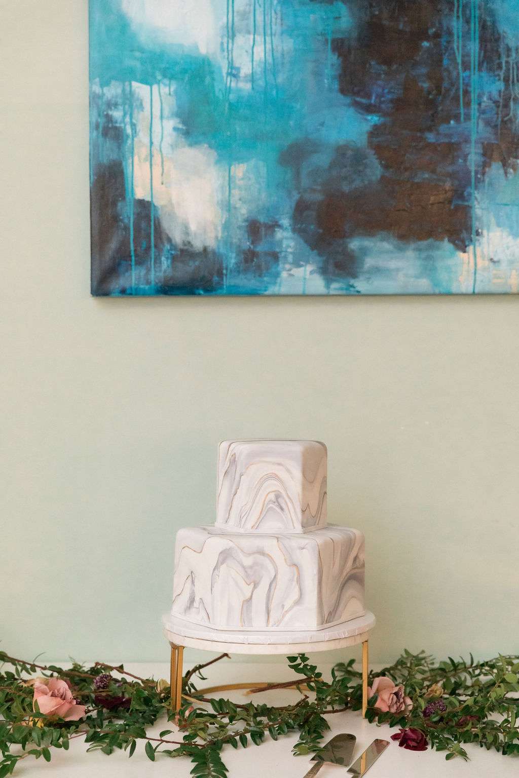 marbled geometric two tier wedding cake on top of gold cake stand
