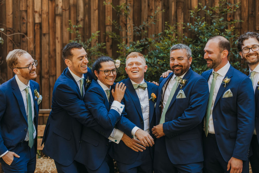 groom and groomsmen in navy suits and green ties portrait shots