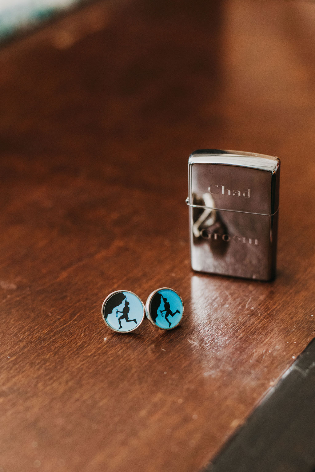 customized lighter with name of groom next to a pair of cufflinks with a picture of a rock climber
