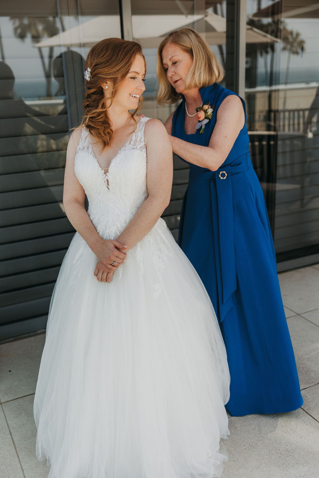 bride in vneck tulle ball gown gets dressed with mother of the bride