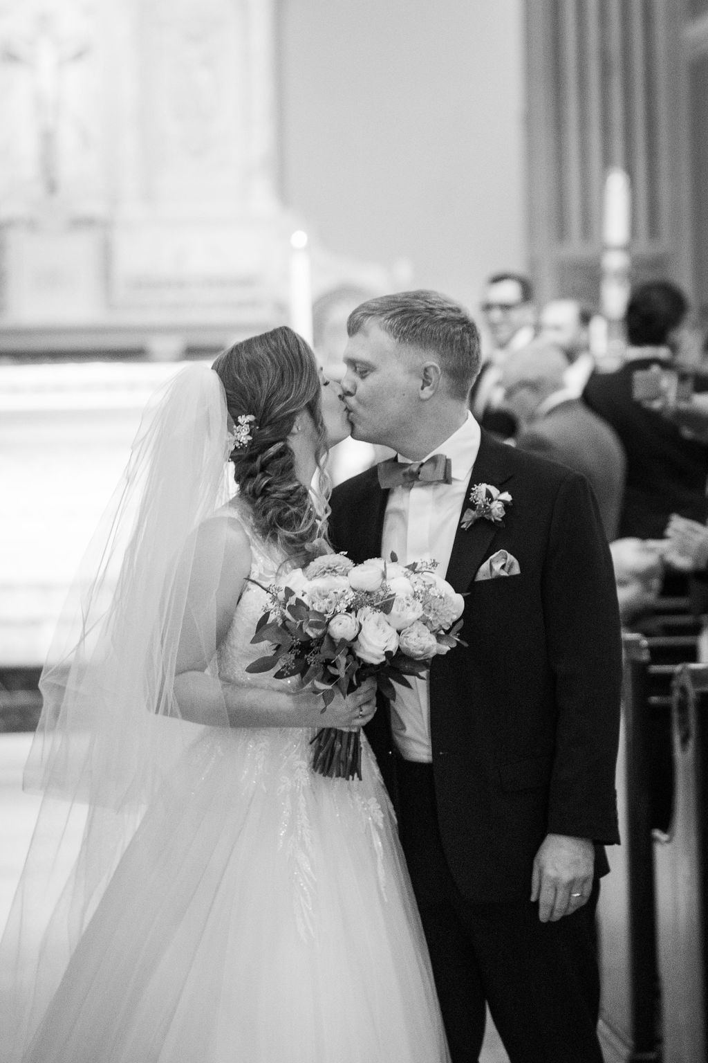 bride and groom kiss during recessional after wedding ceremony at Saint Monica Catholic Church