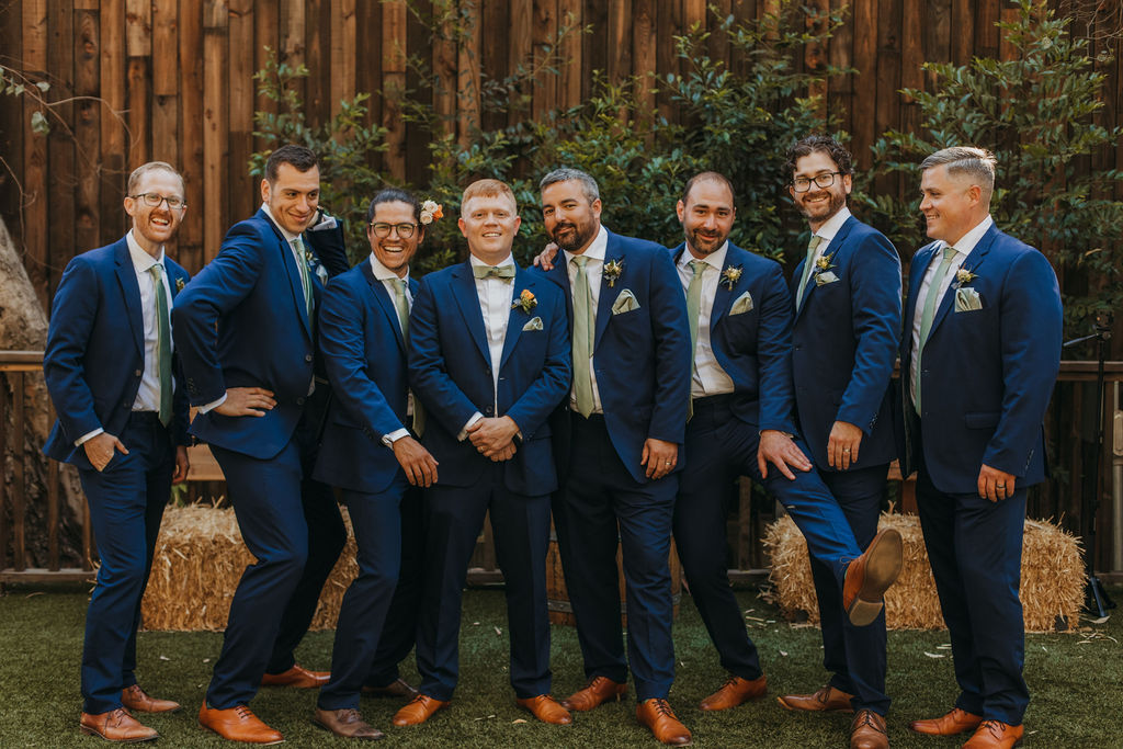 groom and groomsmen in navy suits and green ties portrait shots