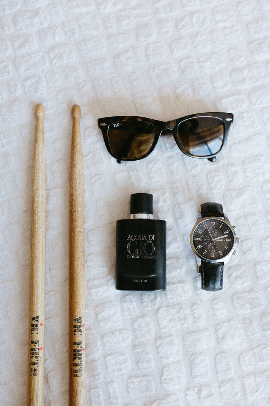 groom details shot with sunglasses, watch cologne and drum sticks