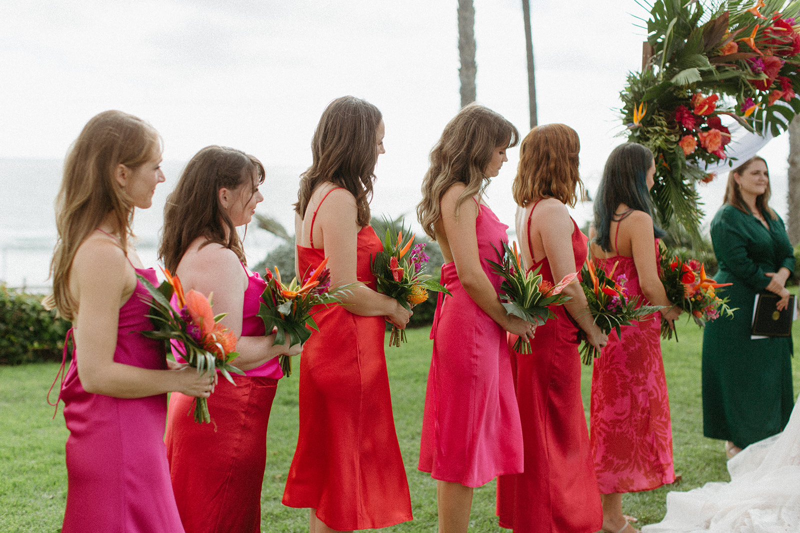 bridesmaids in bright pink dresses stand during tropical wedding ceremony at Ole Hanson Beach Club
