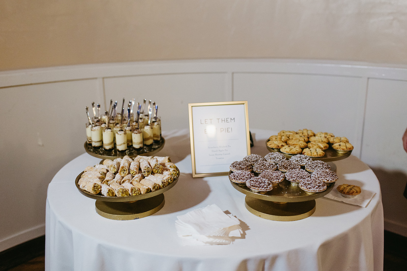 dessert table with gold cake stands and gold framed sign