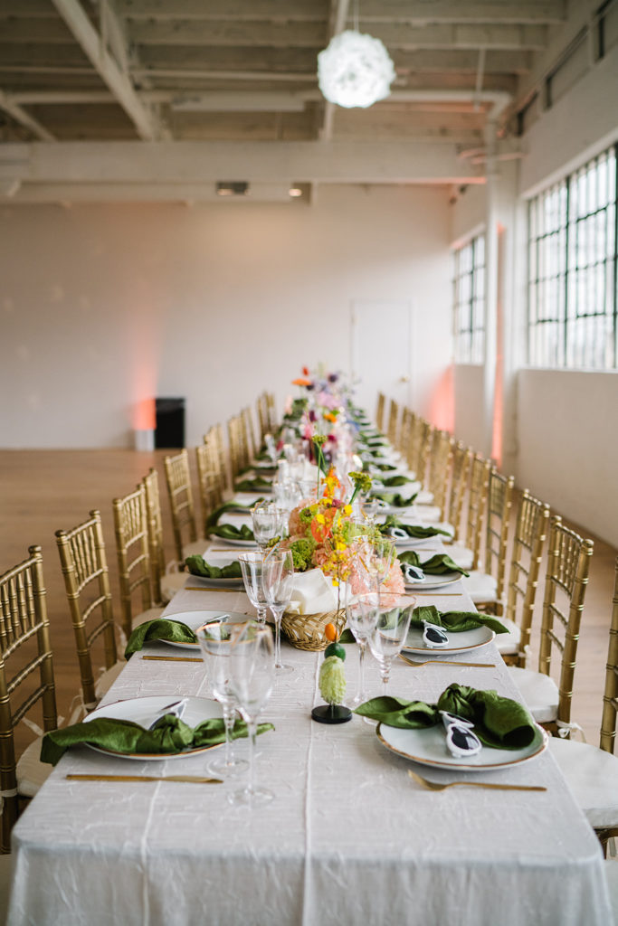 cloud themed wedding reception with disco balls, rainbow inspired floral arrangements, green napkins and white heart shaped sunglasses at The Revery