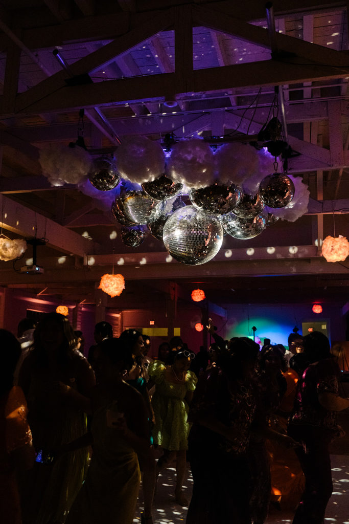 guests dance under disco ball lighting with clouds