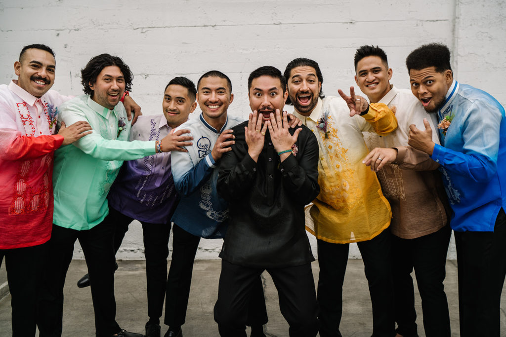 groom stands with groomsmen in rainbow inspired outfits