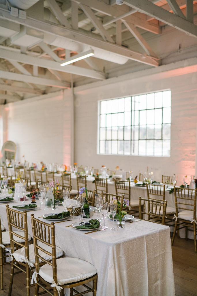 cloud themed wedding reception with disco balls, rainbow inspired floral arrangements, green napkins and white heart shaped sunglasses at The Revery