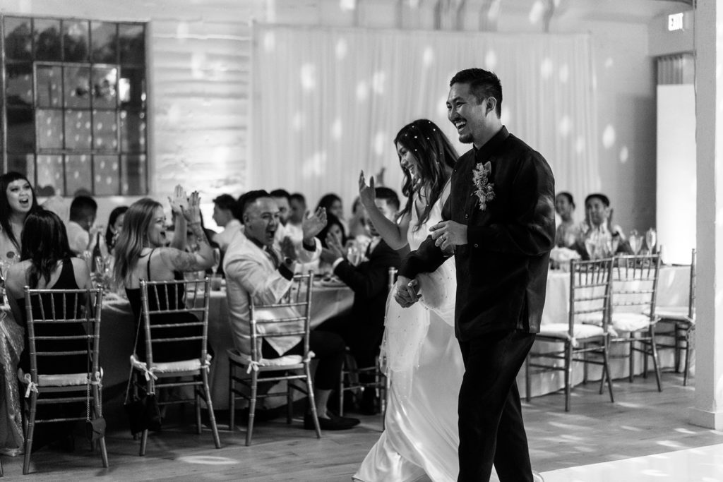 black and white photo of bride and groom grand entrance into wedding reception 
