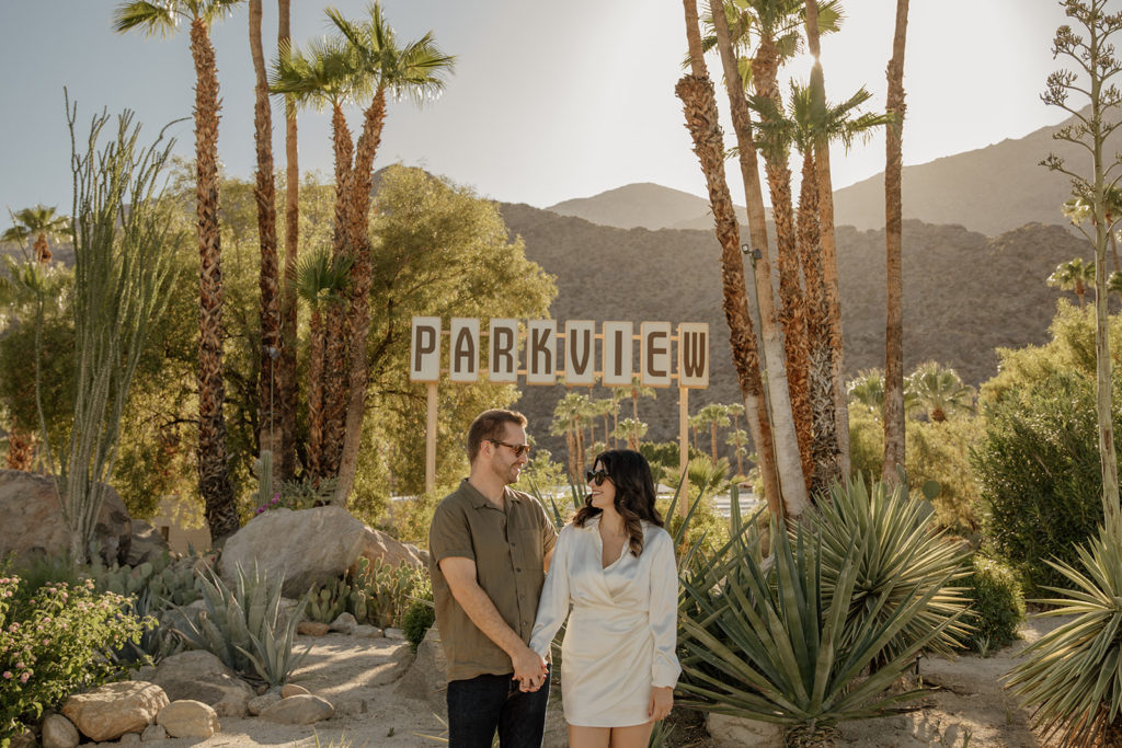 desert engagement photo session with bride in long sleeve silk mini dress and groom in short sleeve army green button up 