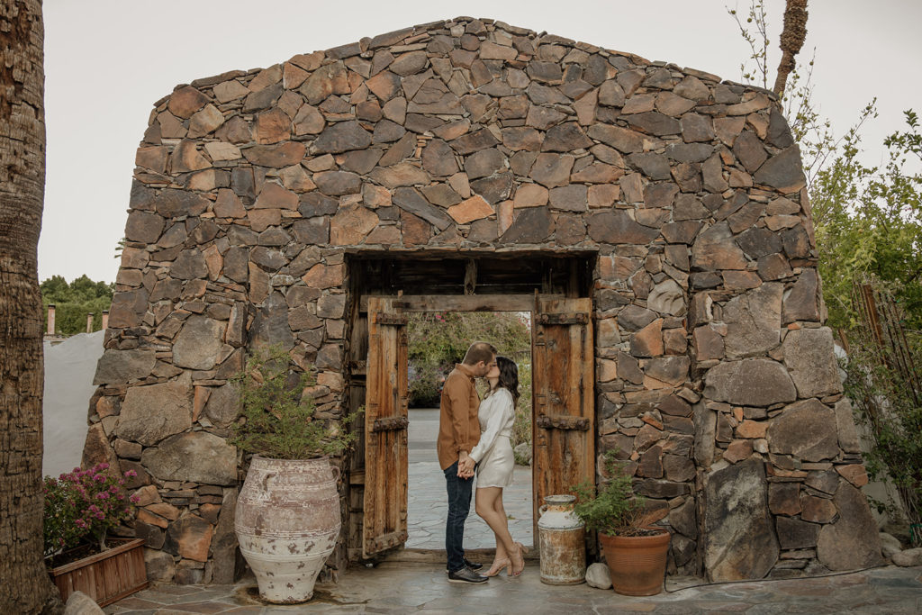 desert engagement photo session with bride in long sleeve silk mini dress and groom in brown button up