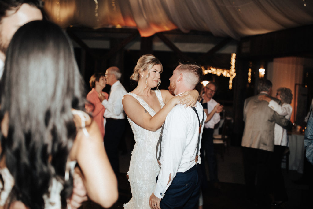 bride and groom dance with guests during reception in The Oak Room at Calamigos Ranch