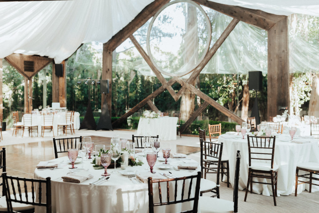 spring wedding reception at The Oak Room at Calamigos Ranch with pink goblets, wooden chairs and white linens