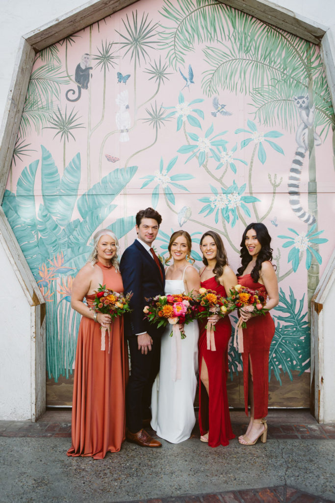 bride with co-ed wedding party in mix matched red outfits 