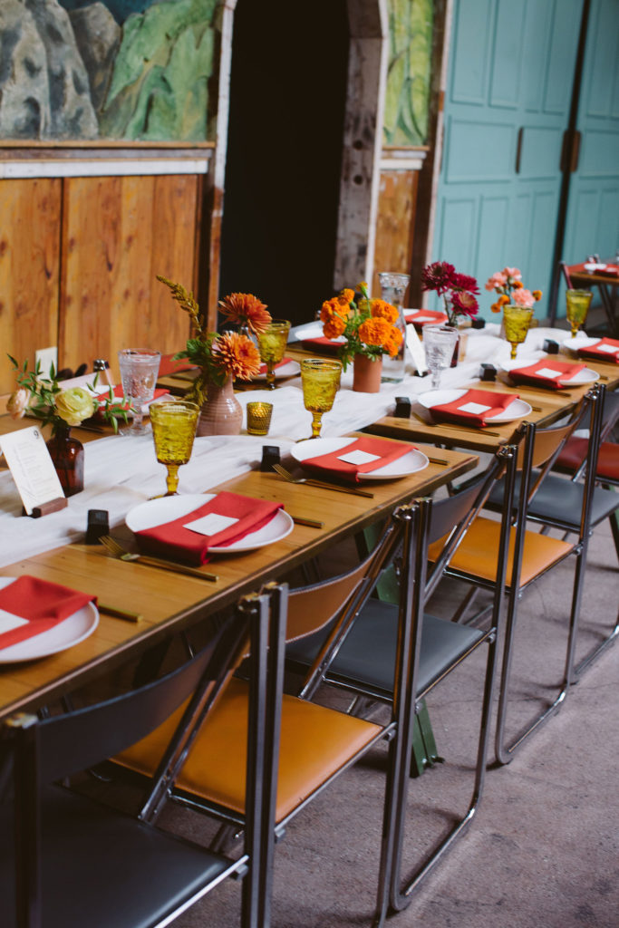 earth toned wedding reception with red linen napkins and amber colored glassware at Valentine DTLA