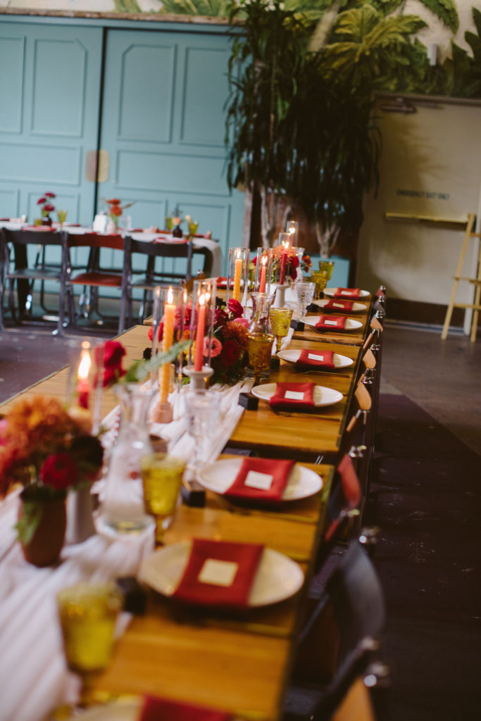 earth toned wedding reception with red linen napkins and amber colored glassware at Valentine DTLA