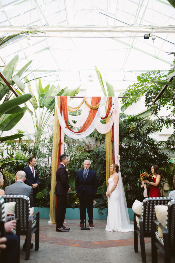 wedding ceremony at Valentine with earth toned drapery creating ceremony arch