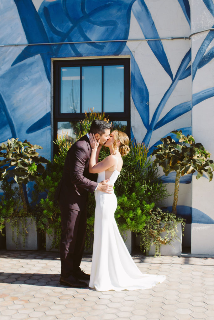bride in modern square neck spaghetti strap wedding dress and groom in deep plum suit have first look outside at Hotel Figueroa