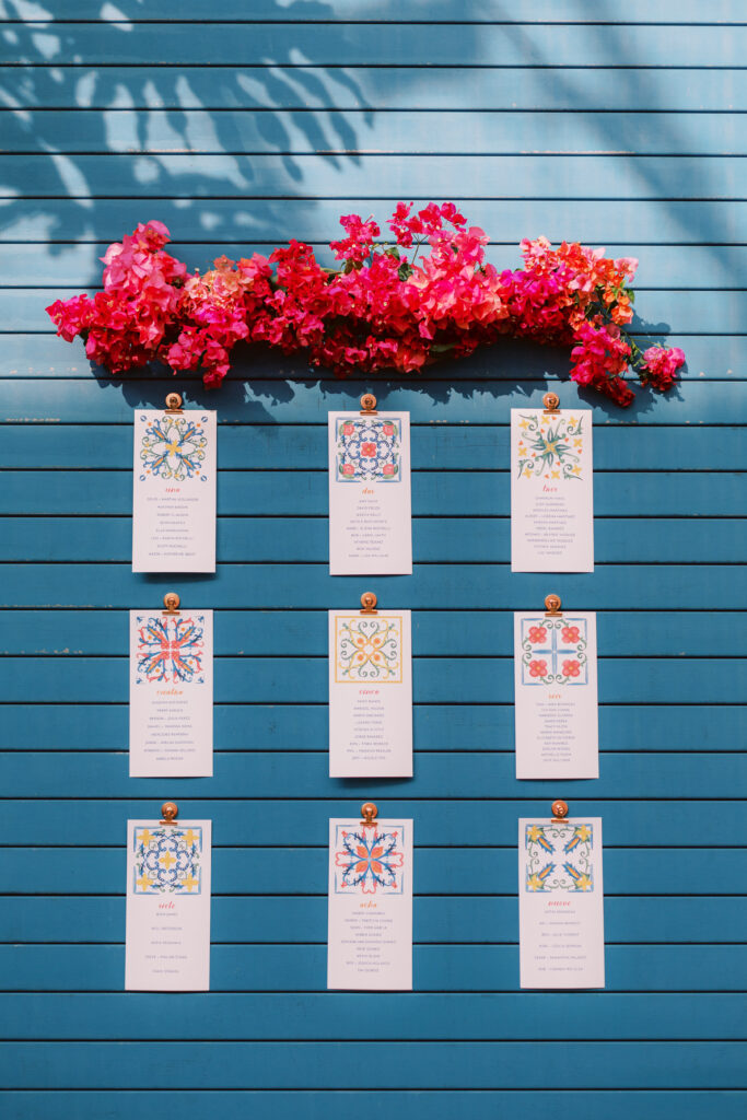 seating chart with Spanish tile inspired artwork below bougainvillea for fiesta themed wedding