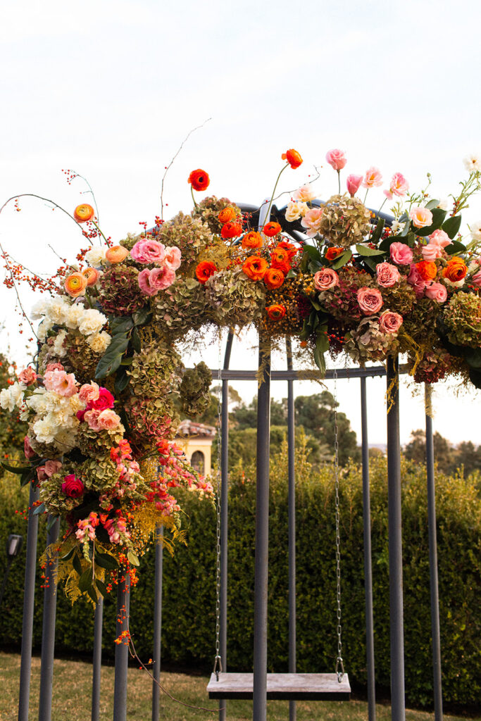 brightly colored floral arrangements on swing for engagement party at private residence
